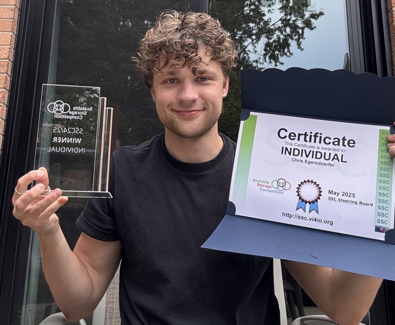 Chris Egersdoerfer holding a certificate and glass award.